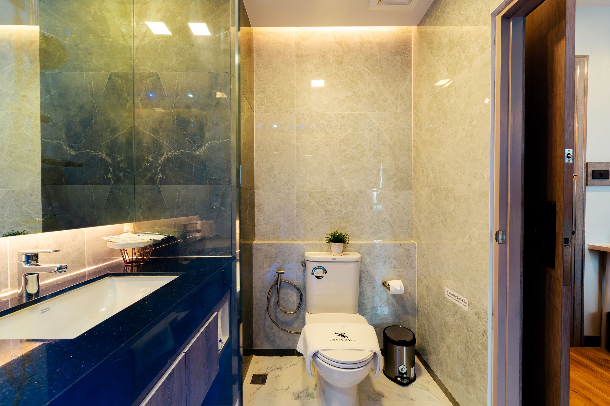 Ein modernes Badezimmer mit Marmorwaschbecken, Toilette und Dusche.
