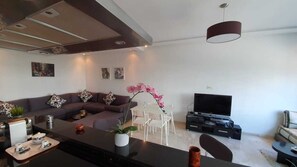 Departamento Confort, 2 habitaciones | Sala de estar | Televisión de pantalla plana de 32 pulgadas con canales vía satélite