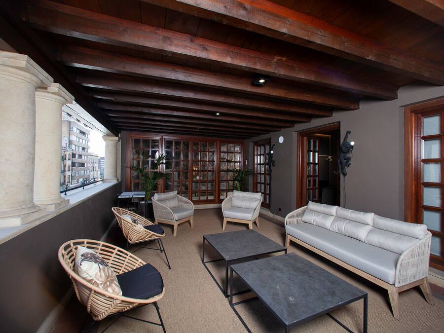 Un coin salon accueillant avec des fauteuils en osier, un canapé et une table basse.