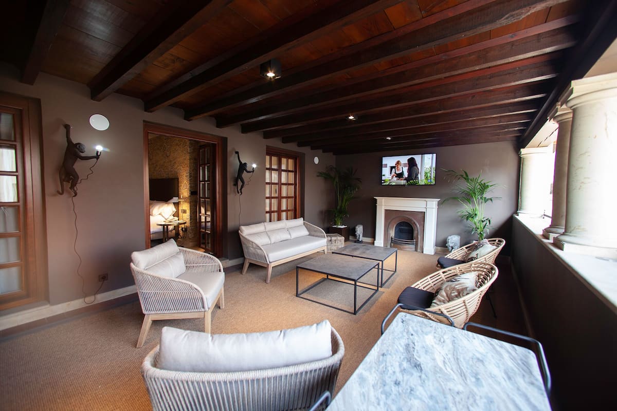 Un salon chaleureux avec une cheminée, des fauteuils confortables et un téléviseur.