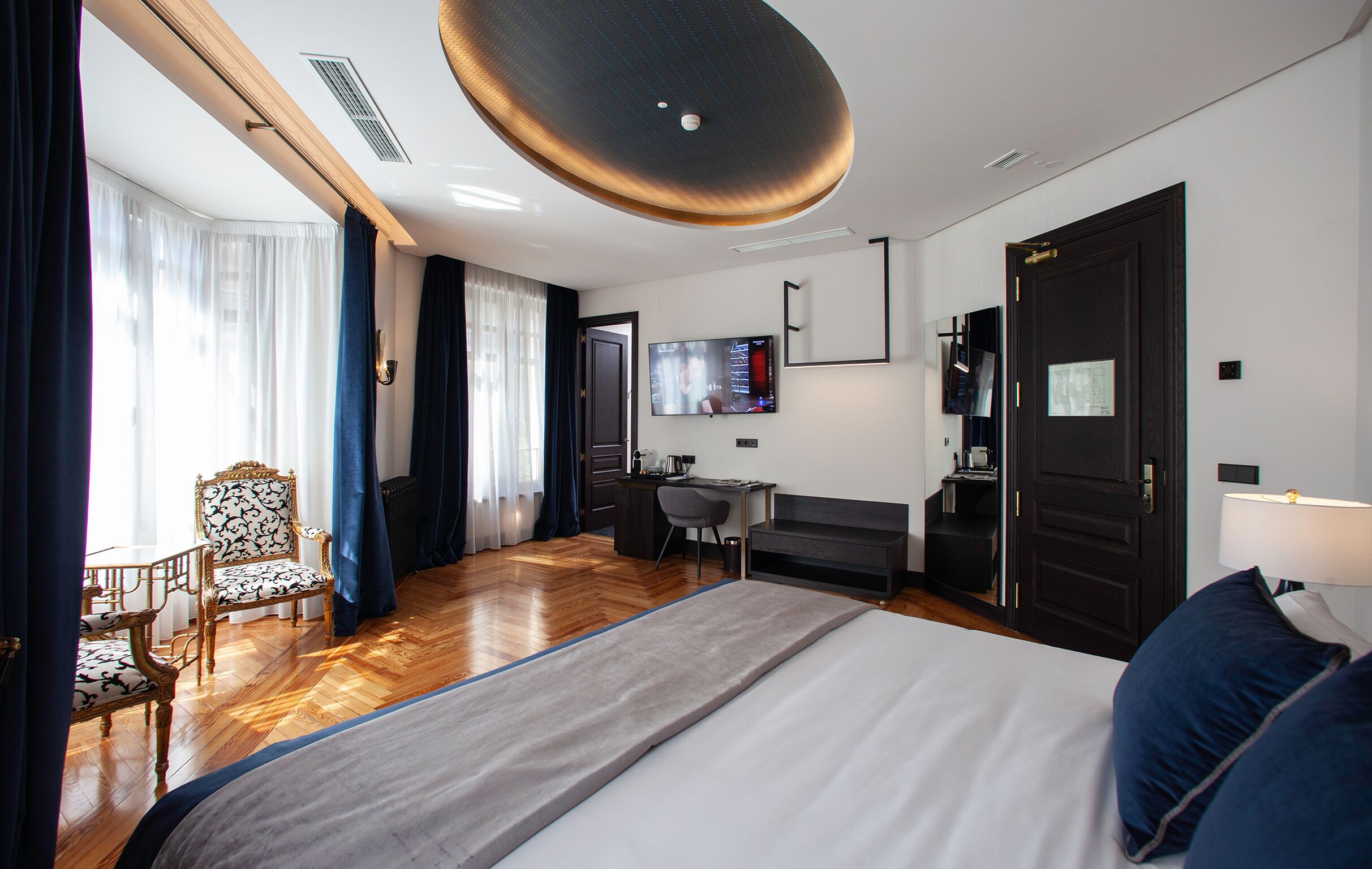 Hotelkamer met een groot bed, een bureau, een stoel, een televisie en een deur.