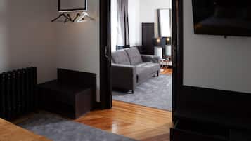 Una sala de estar moderna con un sofá gris, un mueble de entretenimiento negro y un televisor de pantalla plana montado en la pared.