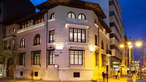 A historic building with multiple stories, large windows, and a prominent corner entrance. - Colonial Palace (León)