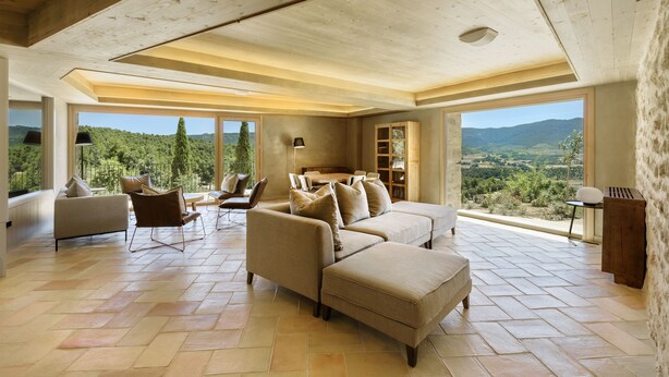 A spacious living room with a large sofa set, a coffee table, and a view of the countryside. - Torre del Marqués Hotel Spa & Winery - Small Luxury Hotels (Monroyo)