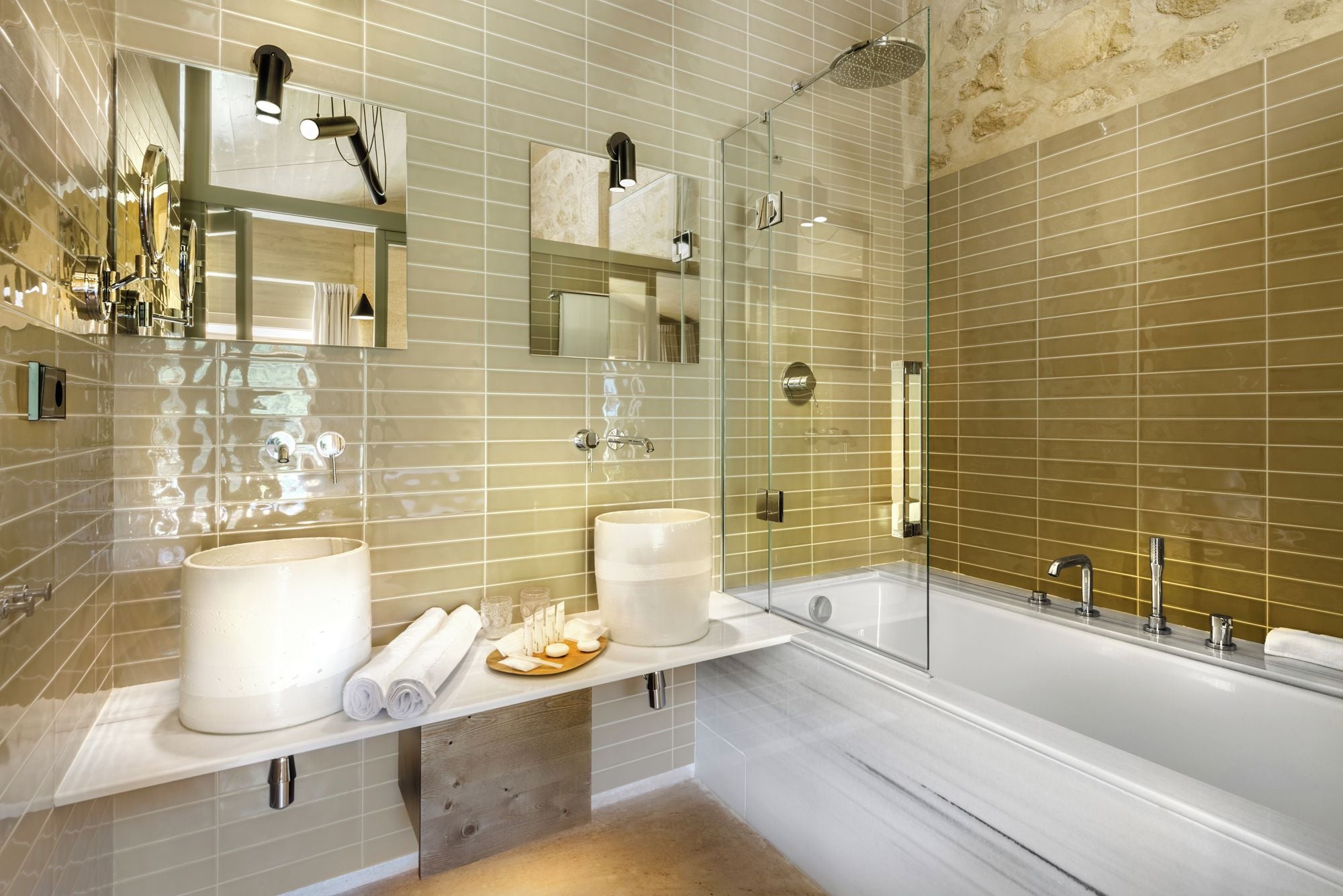Une salle de bain moderne avec deux lavabos, une grande baignoire et une douche séparée par une paroi de verre.