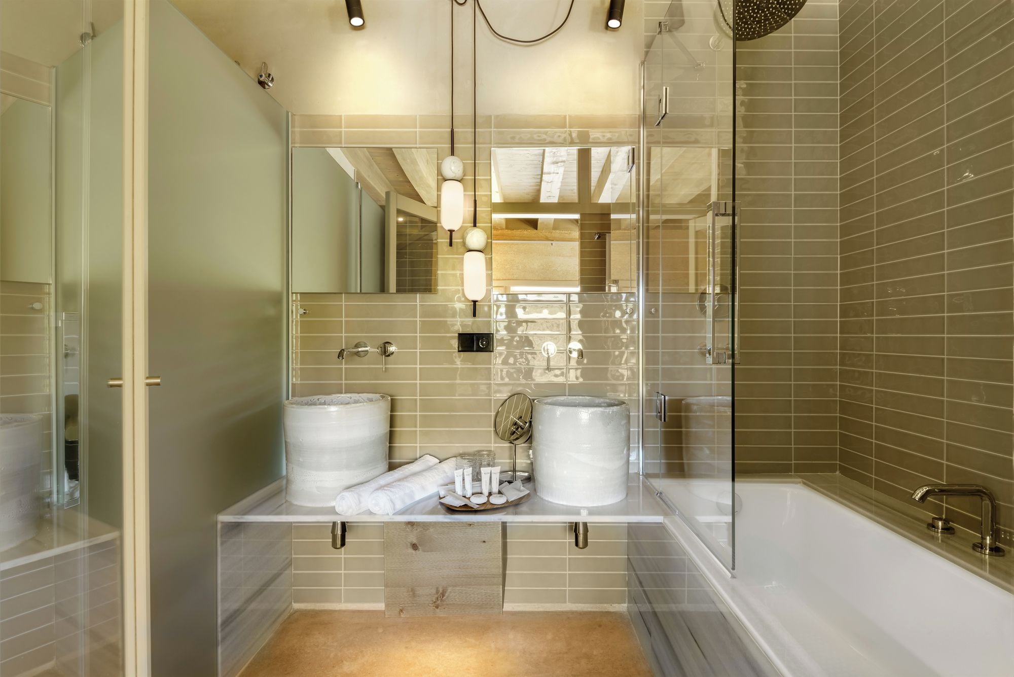 A modern bathroom with a glass shower enclosure, dual sinks, and a bathtub.