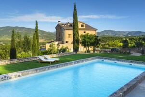 Una piscina al aire libre de temporada, sombrillas