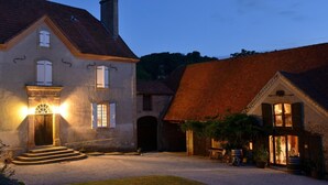 Une maison à deux étages avec une allée en gravier et un petit jardin.