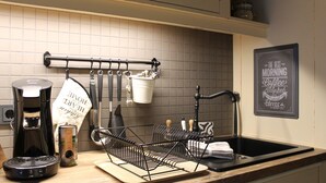 A kitchen with a coffee maker, a hanging utensil rack, and a sink. - Friendly Home - Special apartment "Old Bakery" (Dersdorf)