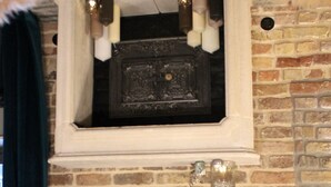 A room with a fireplace, a flat-screen TV, and a clock on the wall. - Friendly Home - Special apartment "Old Bakery" (Dersdorf)