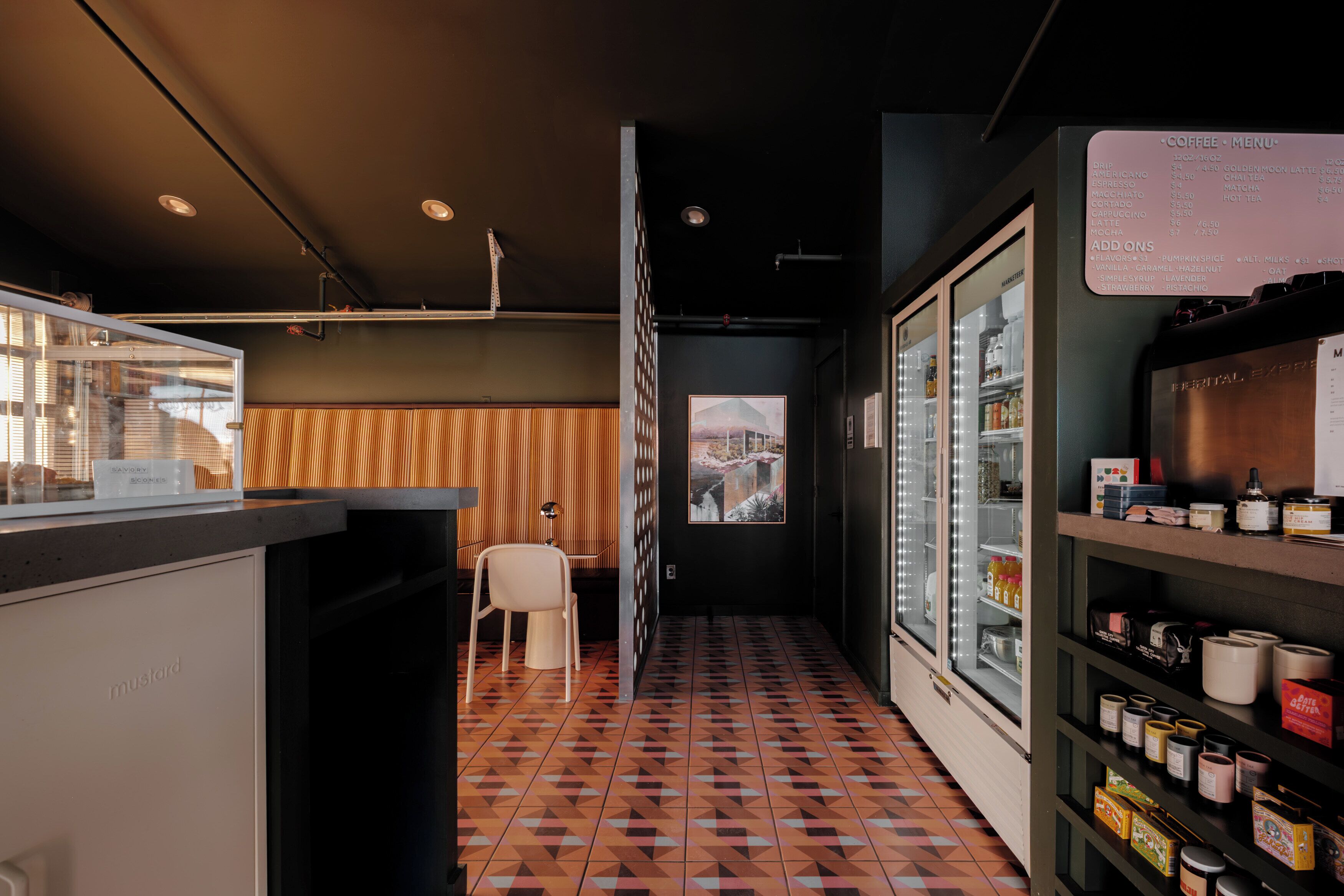 Ein modernes Interieur mit einer Kaffeespeisekarte, einer Sitzecke und Blick durch eine Tür.