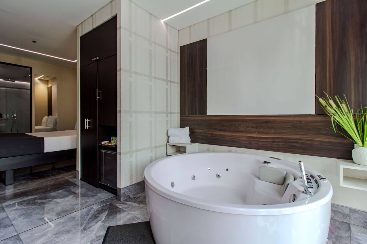 Un baño moderno con una bañera grande, una zona de ducha separada y un tocador con espejo.