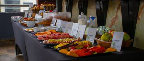 A buffet table with various food items and labels indicating different types of milk and juices.