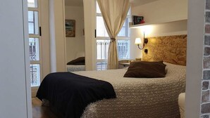 A bedroom with a bed, a headboard, a window with curtains, and a wall-mounted lamp. - STUDIO MUÑOZ # 5 · Studio Muñoz # 5 Old town, 5 minute to beach (Alicante (Alacant))