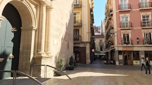 A narrow street with buildings on either side, including a building with a sign that reads "MALLORCA". - STUDIO MUÑOZ # 5 · Studio Muñoz # 5 Old town, 5 minute to beach (Alicante (Alacant))