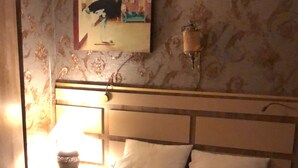 A hotel room with a bed, a nightstand, a lamp, and a painting on the wall. - Gülhane Hotel (Istanbul)