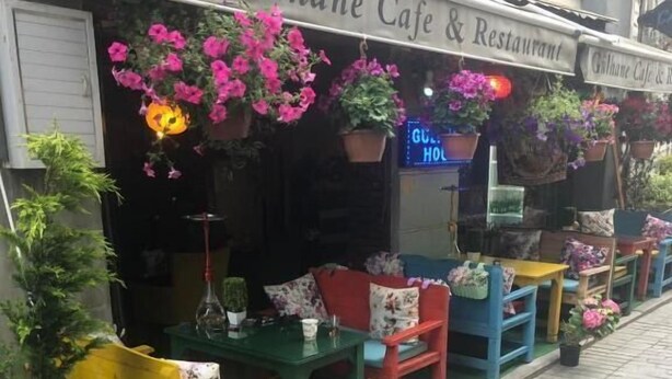 A café with outdoor seating, potted plants, and a neon sign. - Gülhane Hotel (Istanbul)