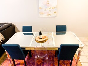 Enjoy meals in this stylish dining area with a glass table, comfortable chairs, and a cozy sofa.
