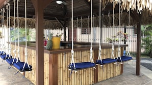 Un bar tiki con columpios colgantes y una barra de madera.