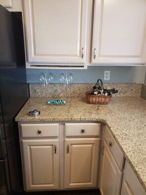 Enjoy cooking in this well-equipped kitchen with a granite countertop, cabinets, and wine storage.