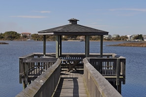 A wooden pier leading to a gazebo over water.