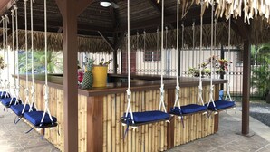 Un bar tiki con columpios colgantes y una barra de madera.