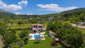 A two-story house with a red roof, a swimming pool, and a small play area. - VILLA ROKO with 4 bedrooms, 32sqm heated pool, playground (Tugare)