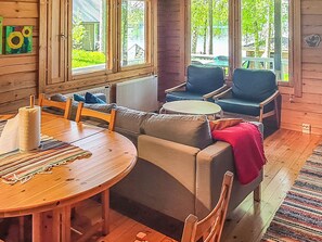 Un intérieur en bois avec une table de salle à manger ronde, deux canapés et une petite table ronde.