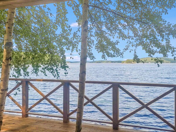 Un muelle de madera con barandilla que da a un cuerpo de agua.