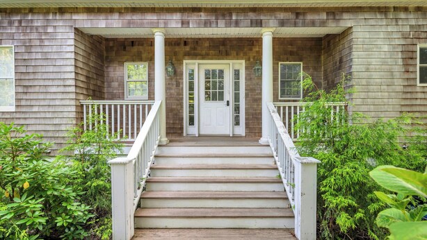 A wooden house with a front porch, white railings, and a double door. - COLONIAL COMPOUND WITH OVERSIZED LIVING ROOMS, GYM, AND ARCADE ROOM, CLOSE... (Southampton)