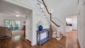 A spacious living room with hardwood floors, a staircase, and a view of the outdoors. - COLONIAL COMPOUND WITH OVERSIZED LIVING ROOMS, GYM, AND ARCADE ROOM, CLOSE... (Southampton)