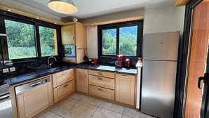 A modern kitchen with wooden cabinets, a stainless steel refrigerator, a microwave, and a coffee maker. - BOURG D'OISANS/ALPE d'HUEZ ★ CHALET Bois & Nature with panoramic view (LE BOURG D'OISANS)