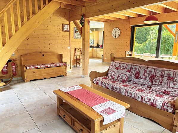 A wooden interior with a sofa, bench, and table.