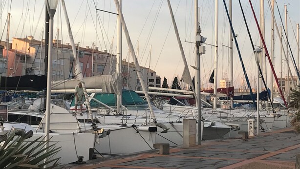 A marina with multiple sailboats docked, some covered with tarps, and a pedestrian walkway in the foreground. - PRETTY GROUND FLOOR CONTEMPORARY GARDEN BROWN (Cap d'Agde)