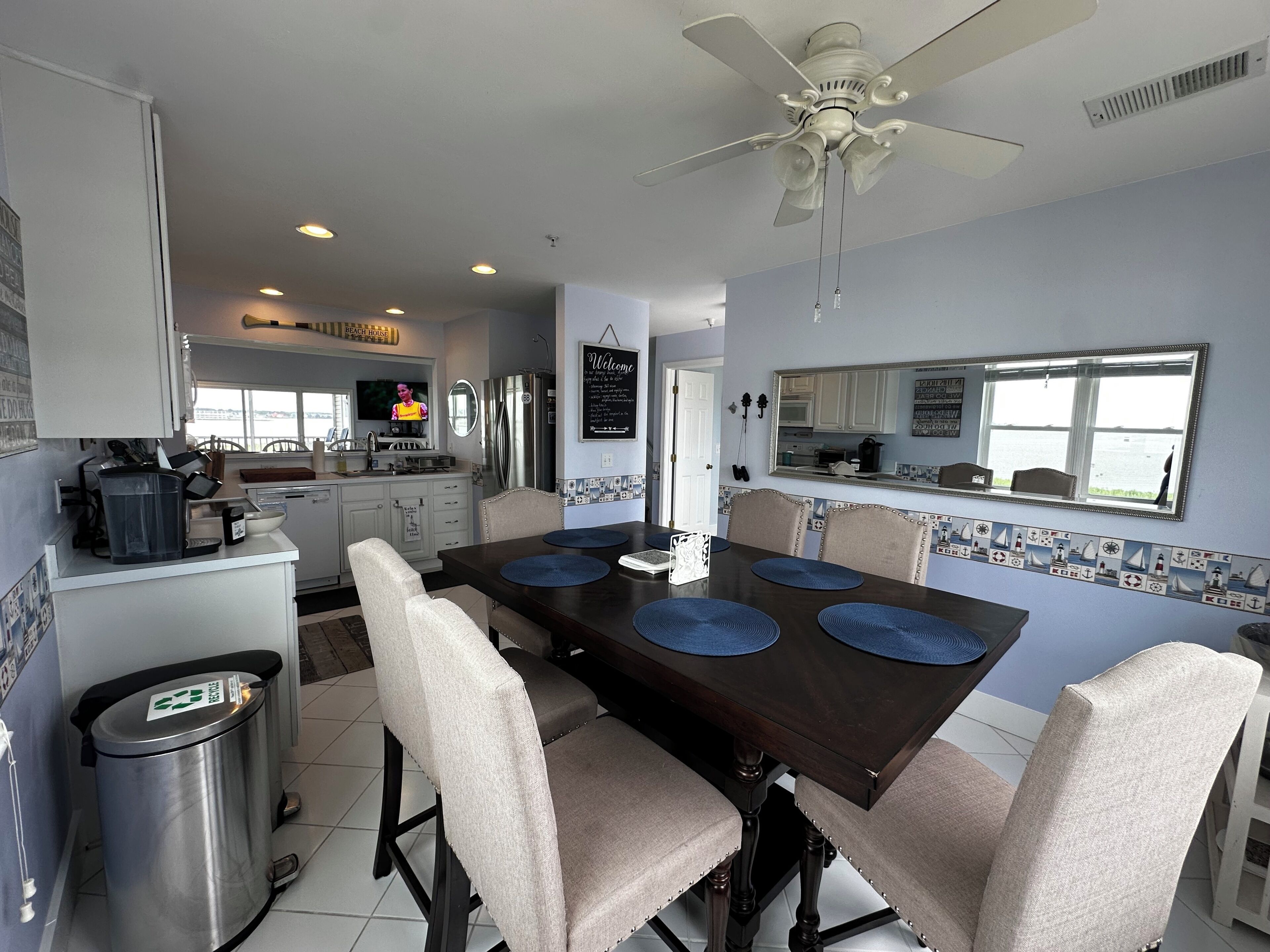 A kitchen with a dining area, a ceiling fan, and a view of the sea.