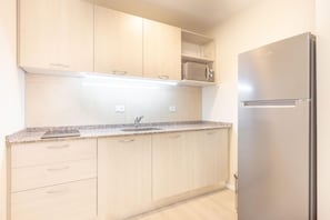 Kitchen features a granite countertop, stainless steel appliances, and a microwave.