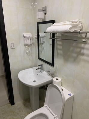 Ein modernes Badezimmer mit Waschbecken, Toilette und Handtuchhalter in Weiß.