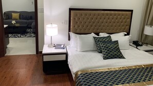 Een hotelkamer met een bed, een nachtkastje met een lamp, een bank en een spiegel.