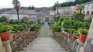 A stone staircase leading to a courtyard with neatly trimmed hedges and potted plants. - Vacation apartment Glicine - Vigna Luisa Resort - Close to Rome (Genzano di roma)
