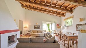 A spacious living area with a fireplace, a sofa, a dining table, and a kitchen area. - Vacation apartment Glicine - Vigna Luisa Resort - Close to Rome (Genzano di roma)