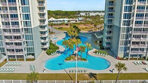 Un hôtel de grande hauteur doté de nombreux balcons, d’une piscine centrale et d’un espace piscine aménagé.