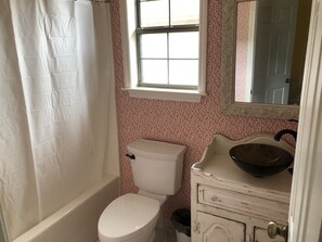 Tina con regadera, toallas, papel de baño 