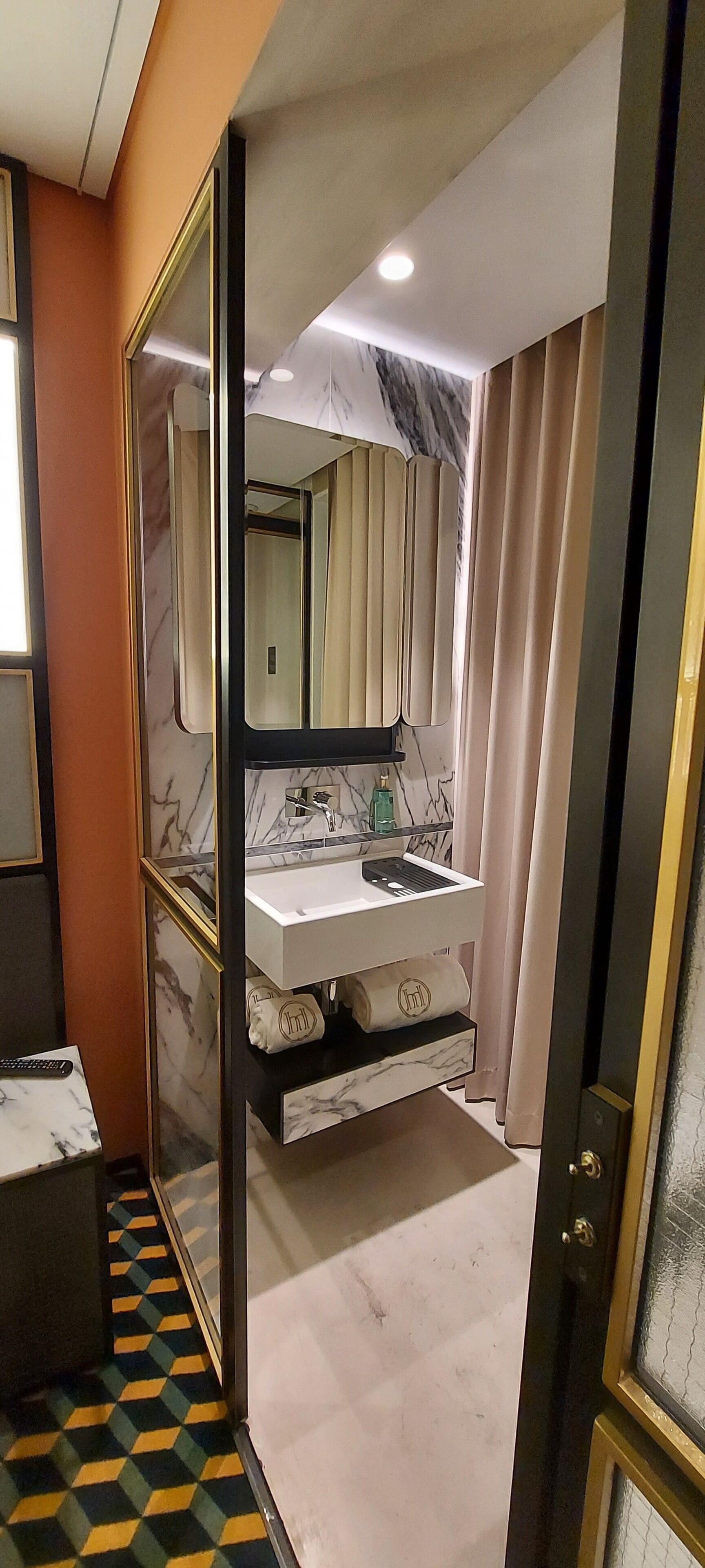 A bathroom with a marble vanity, a large mirror, and a modern sink.