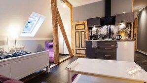 A modern kitchen with dark cabinets, a black range hood, and a tiled backsplash. - Apartment Fiolet by Interhome (Szczawno Zdroj)