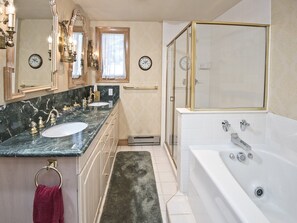 A bathroom with a marble vanity, a bathtub, and a glass-enclosed shower. - Meadows Townhome (Avon)
