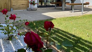 A modern building with a wooden door, a covered patio, and a bench. - Small garden level for a seaside holiday (LE CONQUET)