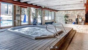 A hot tub in a room with large windows, wooden flooring, and a tiled wall. - River Run - Steps to Ski, Hot Tubs, Heated Pool, Ice Rink (Keystone)