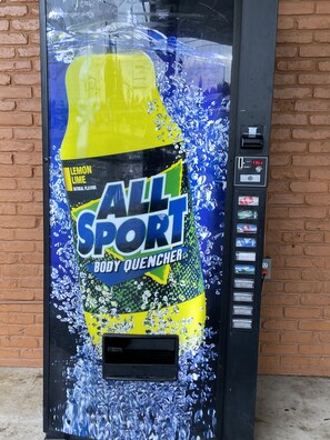 A vending machine with a large All Sport body quencher advertisement. - Cozy Inn (Shreveport)