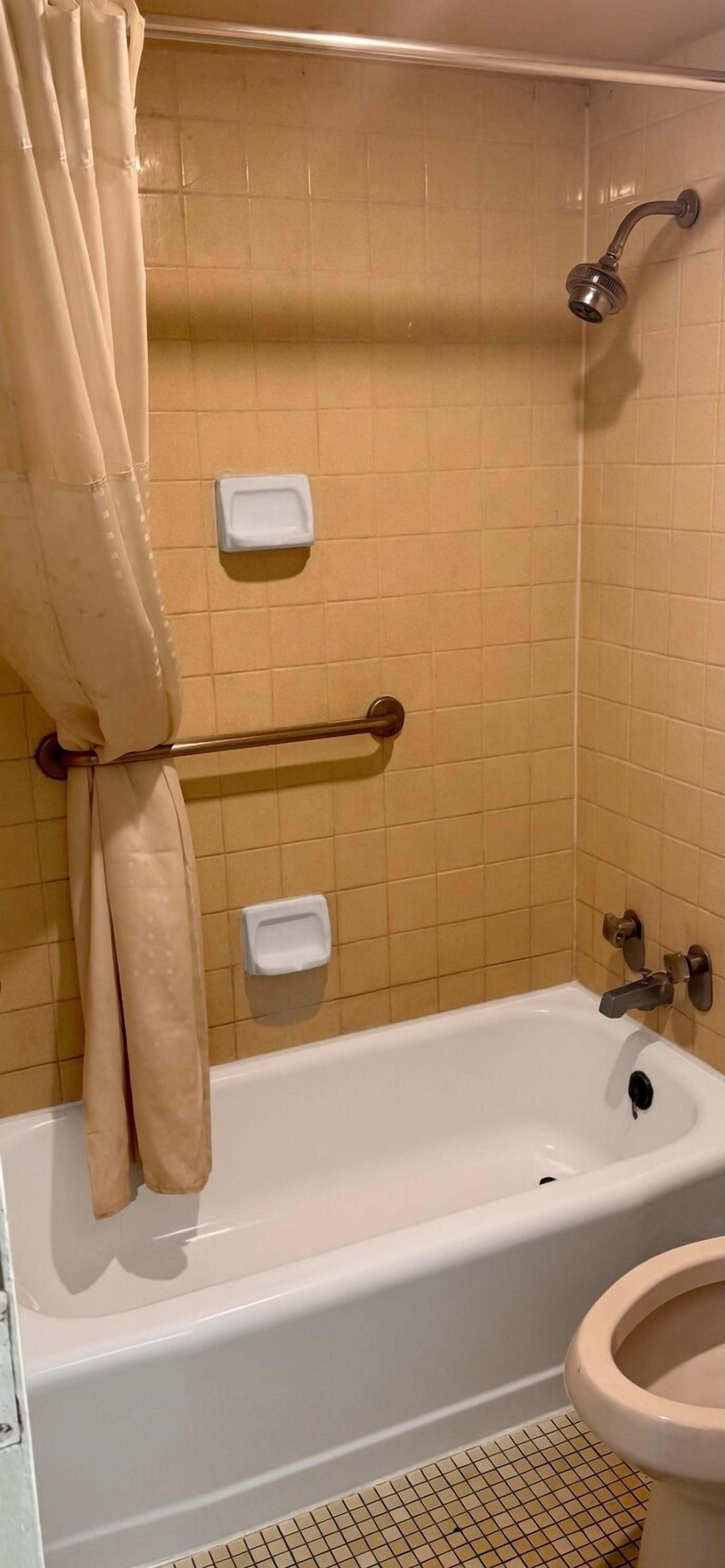 A bathroom with a bathtub, toilet, and shower.