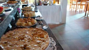 Ein reichhaltiges Buffet mit verschiedenen Speisen, darunter ein großer Kuchen mit cremiger Füllung.